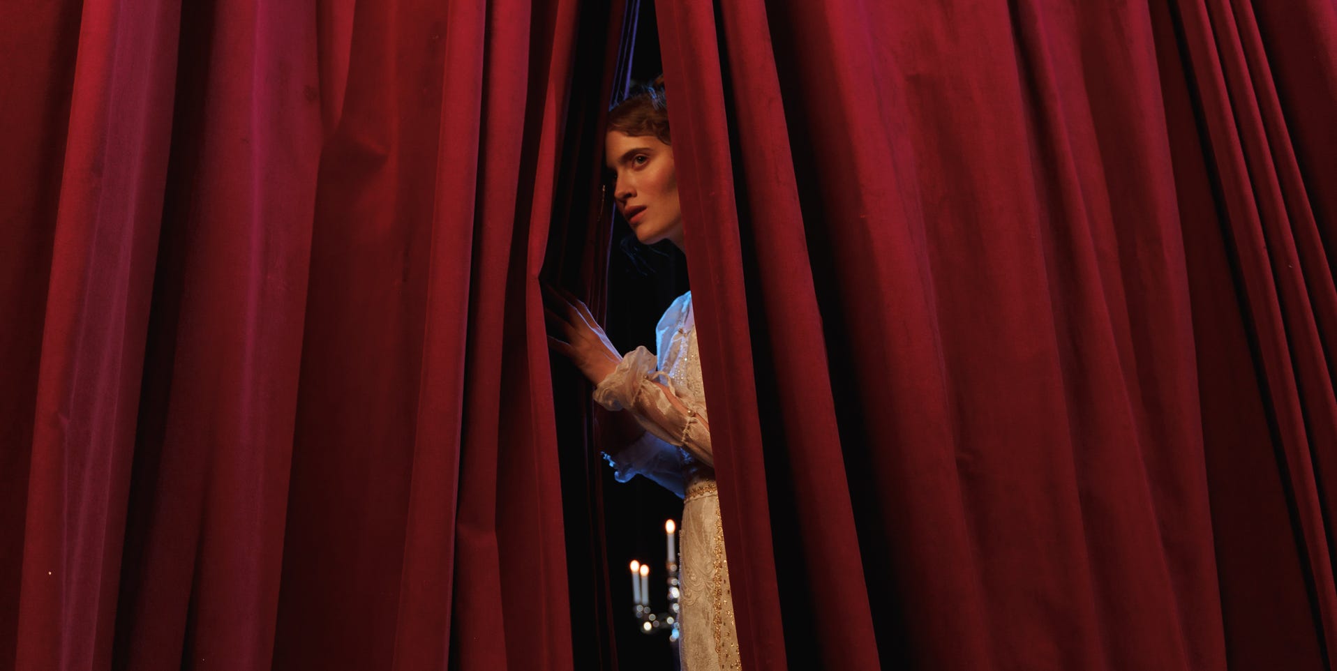 Woman Standing Behind Red Curtain
